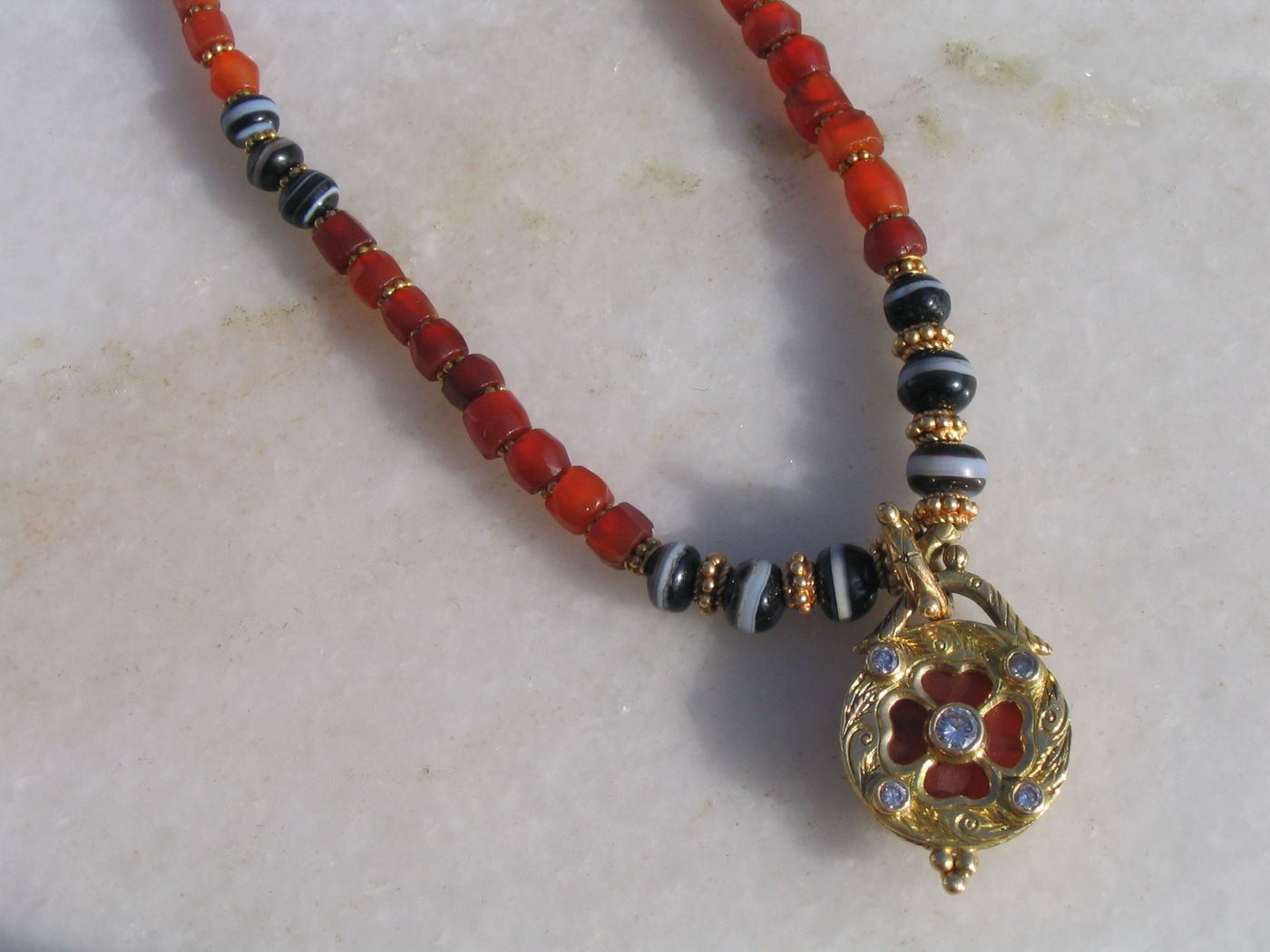 Carnelian Sphere Pendant — Carnelian, blue sapphire, diamond, openwork gold